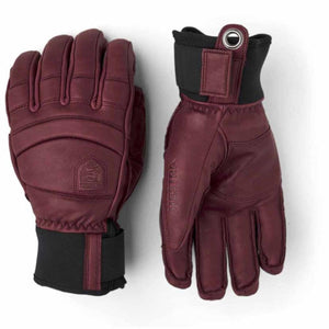 Hestra burgundy leather ski gloves with black cuffs and metal eyelet