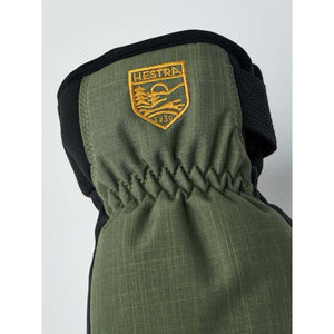 Close up of olive green Hestra glove with embroidered brand logo
