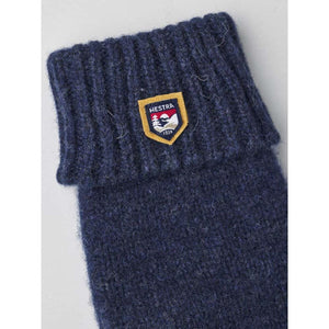 Navy blue ribbed knit Hestra glove cuff with brand logo patch