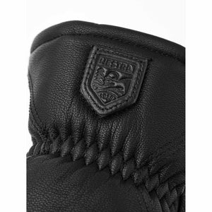 Black leather Hestra glove with embossed brand logo patch
