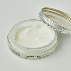 Open glass jar of Hestra leather lotion with white cream