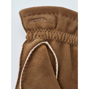 Brown suede Hestra glove cuff with embossed logo