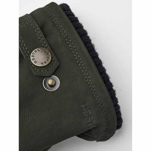 Close up of Hestra olive green leather glove cuff with metal snap button and black ribbed knit lining