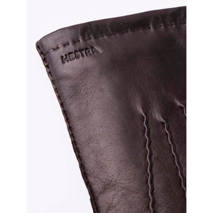 Close up of dark brown Hestra leather glove cuff with embossed logo