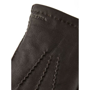 Close up of brown Hestra leather glove with embossed logo