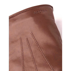 Brown Hestra leather glove detail with embossed logo and decorative stitching