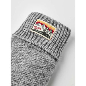 Grey ribbed knit Hestra glove cuff with branded mountain logo patch