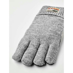 Grey knit glove with a mountain landscape brand patch on the cuff