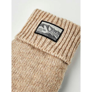 Beige ribbed knit Hestra glove cuff with mountain graphic brand patch