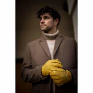 Man wearing Hestra yellow leather gloves with a brown coat and turtleneck