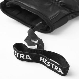 Black Hestra glove with attached elastic wrist strap