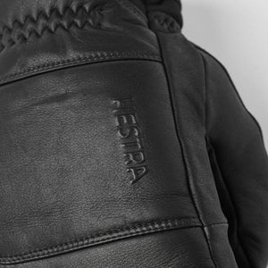 Close up of black leather Hestra glove with embossed logo