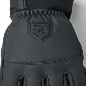 Black Hestra leather glove with embossed brand logo patch