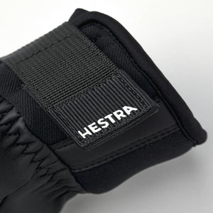 Black Hestra glove cuff with adjustable velcro strap and white brand logo