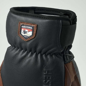 Black Hestra leather glove with branded patch and adjustable wrist strap