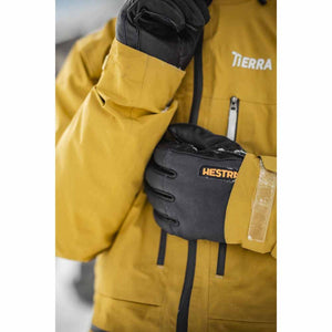 Person wearing black Hestra gloves and a yellow Tierra jacket