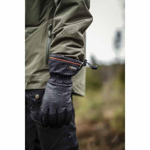 Person wearing black Hestra CZone waterproof gloves with orange trim