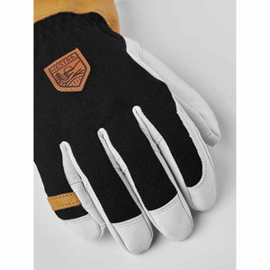 Hestra glove with black fabric back white leather fingers and tan leather cuff detail