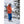 Skier wearing orange jacket and blue pants adjusting gloves in snowy mountain setting