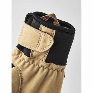 Close up of tan and black glove cuff with velcro strap and pull tab