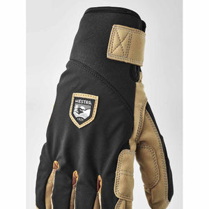 Hestra black and tan glove with velcro wrist strap and brand logo patch