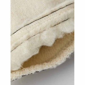 Close up of cream colored wool fabric with visible stitching and textured edge