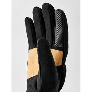 Hestra black glove with tan leather palm patch and textured grip detail on index finger