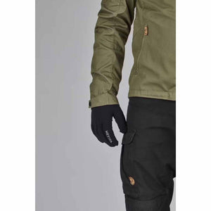 Person wearing a green jacket and black Hestra gloves