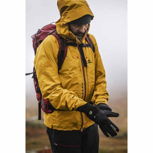 Person wearing a yellow jacket and Hestra black gloves outdoors