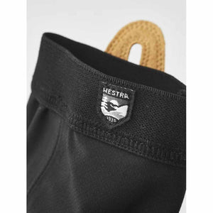 Close up of Hestra glove cuff with brand logo patch and tan leather pull tab