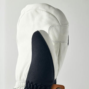 White leather mitten with black thumb panel and brown leather strap detail