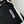 Hestra logo embroidered on black fabric with white leather trim