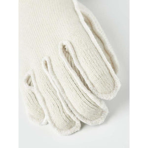 Close up of a cream colored knit glove with visible stitched seams
