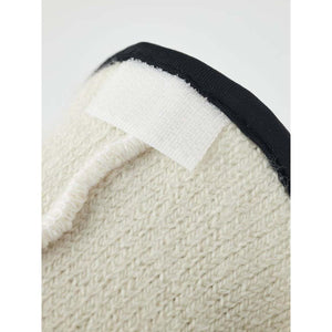 Close up of cream textured fabric with a white velcro strip and black trim