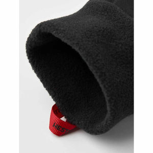 Black fleece lined cuff of a Hestra glove with a red pull tab