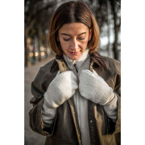 Woman wearing a brown wax jacket over a cream fleece and matching cream fleece mittens