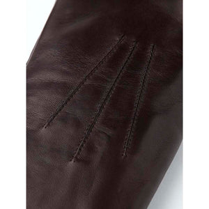 Close up of dark brown leather glove with decorative stitching on the back
