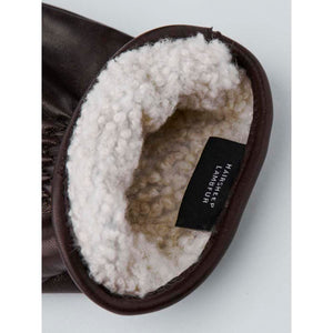 Brown leather glove interior with cream colored lambfur lining and material tag