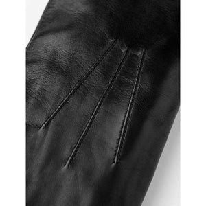 Close up of black leather glove with decorative stitching on the back