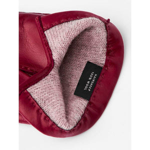 Interior of a red leather glove showing a wool lining and a label stating hairsheep 100 percent wool