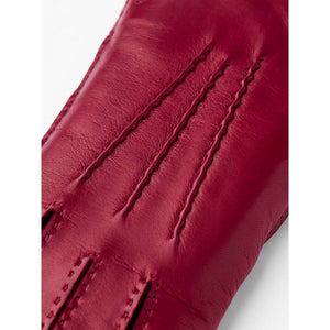 Close up of red Hestra leather glove with decorative stitching on the back