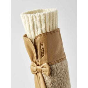 Hestra tan leather glove with cream ribbed cuff and small leather bow detail