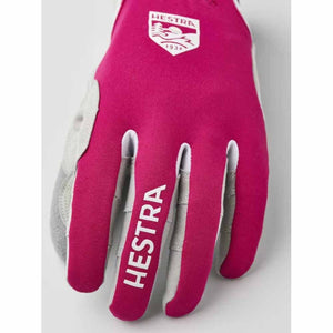 Pink Hestra glove with white logo and text on the back of the hand