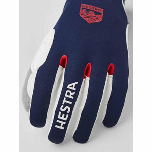 Hestra navy and white ski glove with red logo patch and white text branding on the index finger