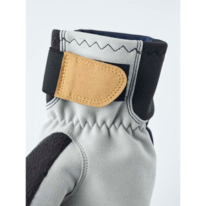 Close up of grey glove cuff with tan velcro strap and black trim