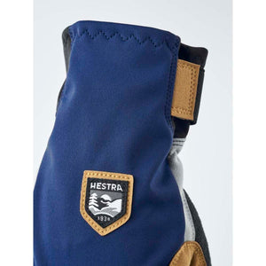 Hestra blue glove with tan leather patch and Hestra logo