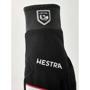 Black Hestra glove with logo patch and white text branding