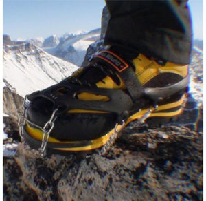 Hillsound traction device attached to a yellow hiking boot on a snowy mountain