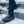 Person wearing Hillsound traction cleats over brown leather boots on snowy concrete steps