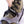 Hand pulling the Hillsound branded strap on a hiking boot equipped with traction cleats